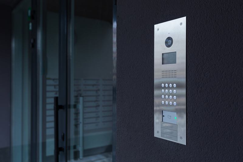 Video intercom panel beside a glass entry door